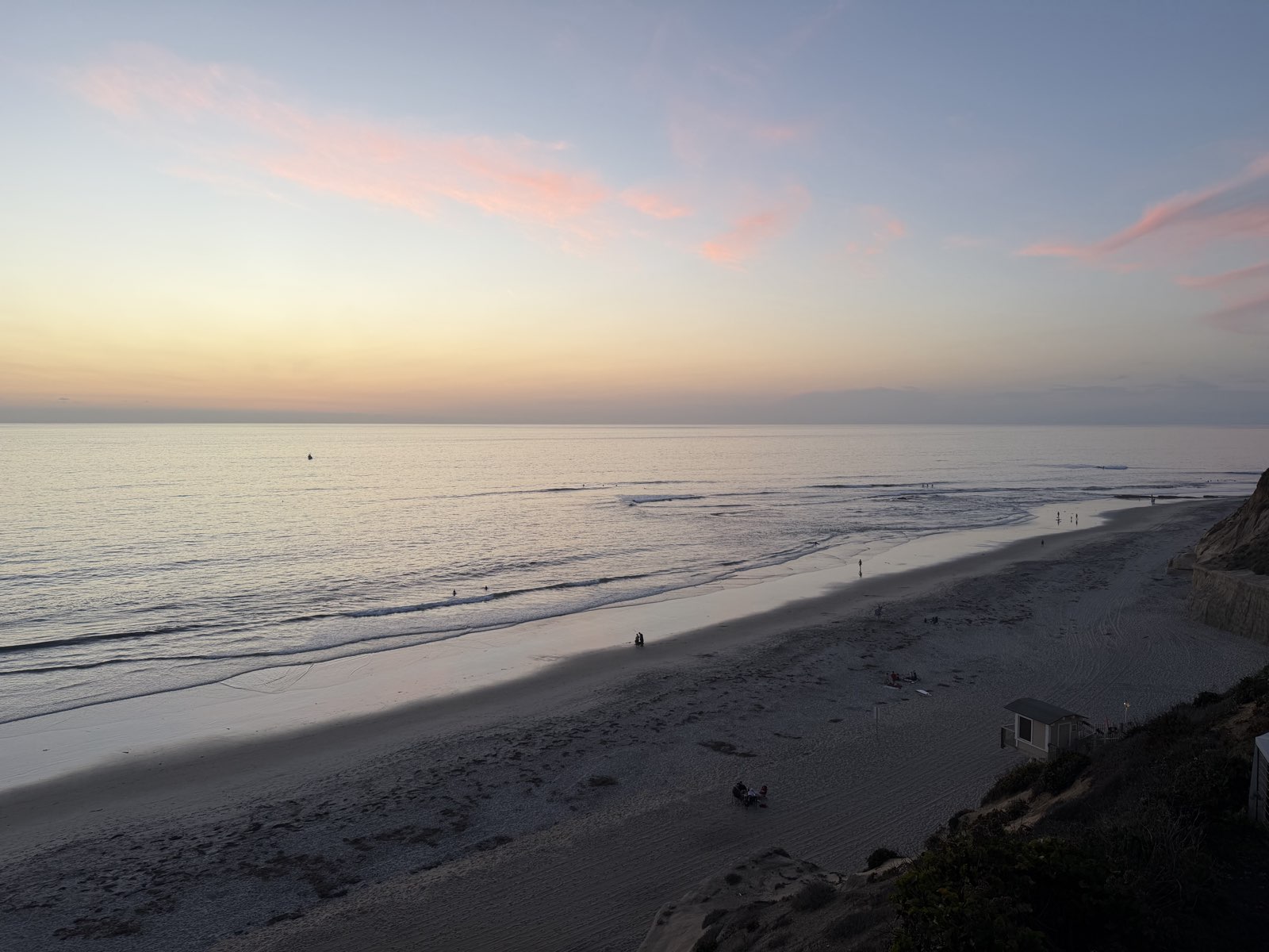 Sunset over the Pacific at Fletcher Cove, pink clouds and the lifeguard shack on the sand